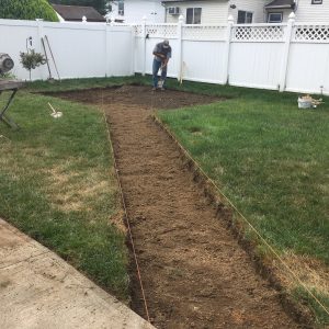 worker executing backyard grass excavation