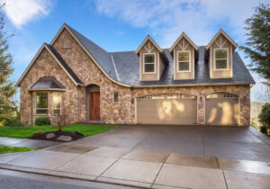Beautiful, Newly Built Luxury Home Exterior with Stone Facade and Three Car Garage, and Gables